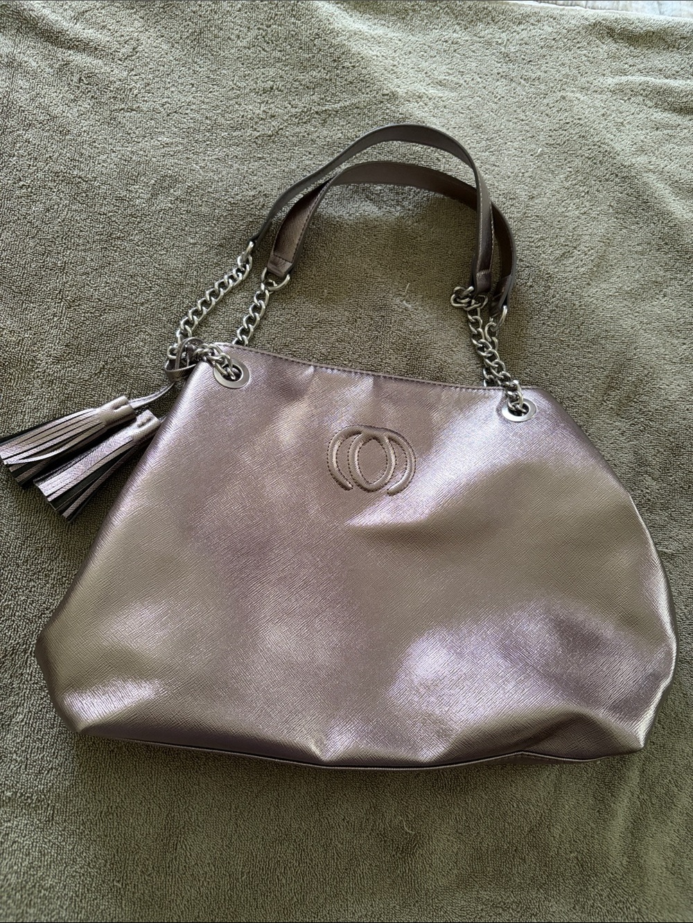 Metallic silver Women Tote Bag with Tassel Accent. Has magnetic snap closure.